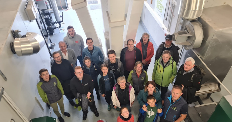 Gruppe von Mitarbeitenden in einer Industriehalle blickt in die Kamera.