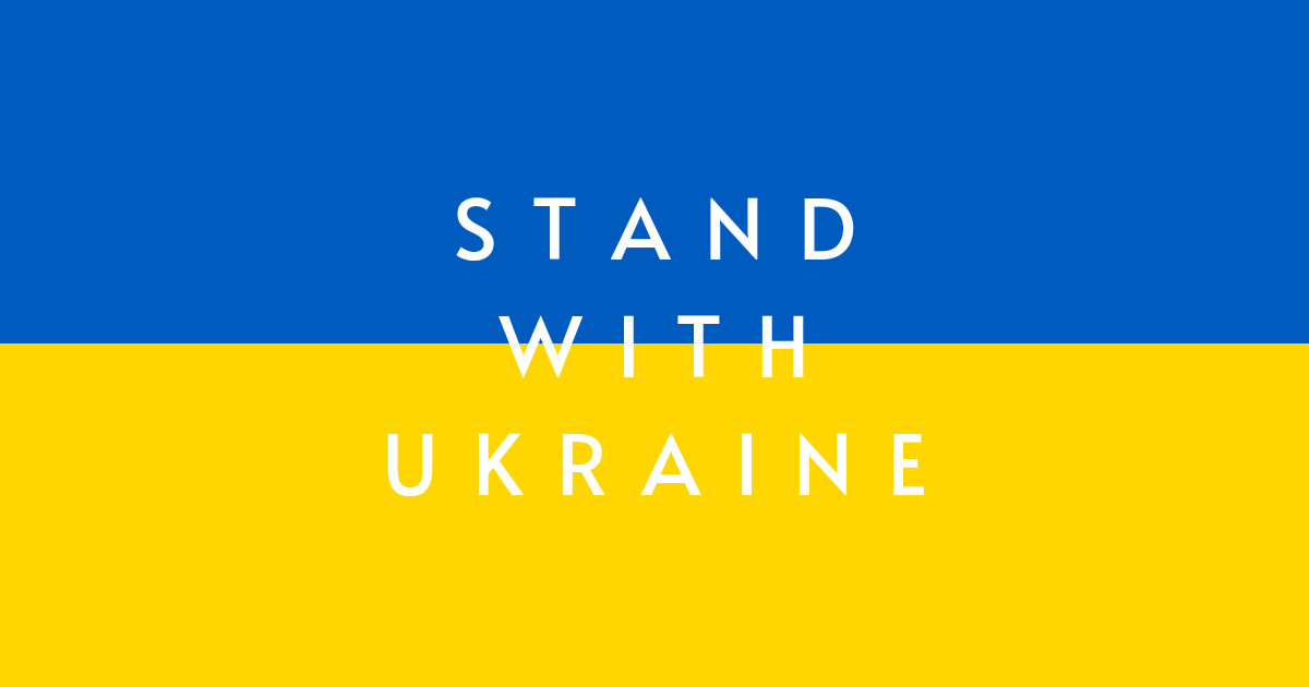 Ukraine-Flagge mit blauer Oberhälfte, gelber Unterhälfte und weißer Aufschrift Stand with Ukraine