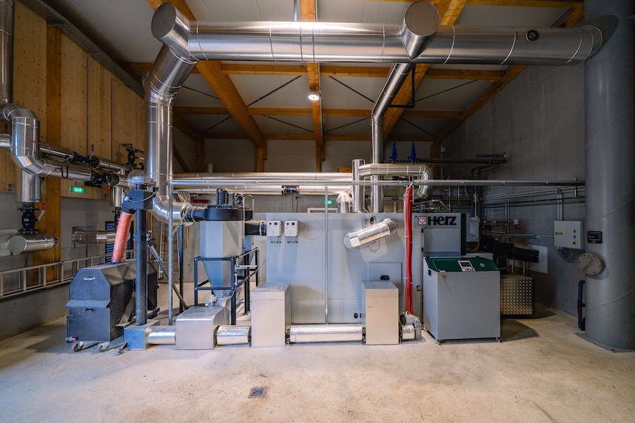 Industrieanlage mit Rohrleitungen, Pumpen und Steuerungseinheit in einer Werkshalle.