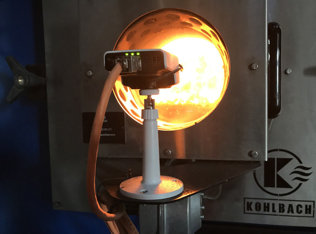 Industrieller Brenner/Ofen mit leuchtend orange Glühkugel, Messgerät auf Stativ, Kabel, Metallrahmen und Kohlbach-Logo.
